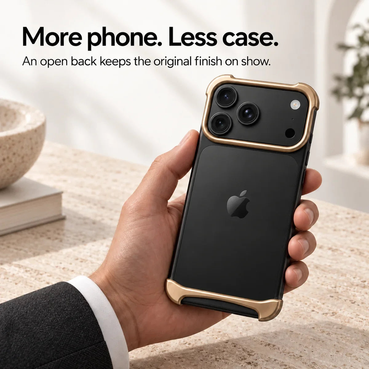 Gold metal phone bumper held above a pale stone desk, showing the exposed phone back #color_Champagne Gold