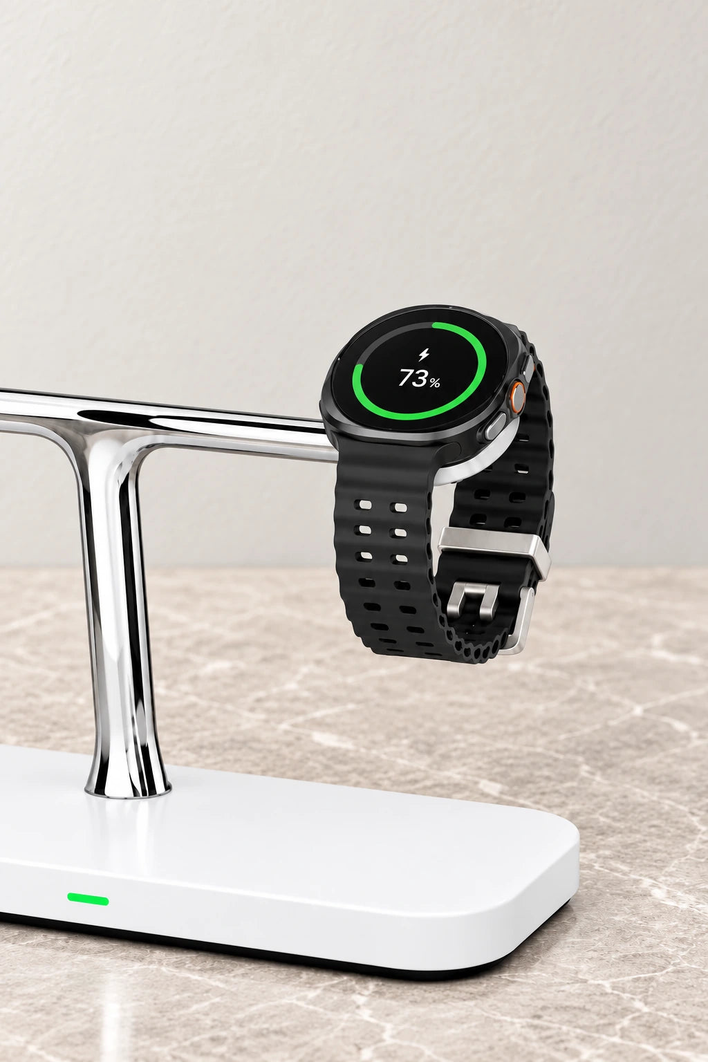 A round black watch charging on the upper arm of a white and chrome wireless dock.