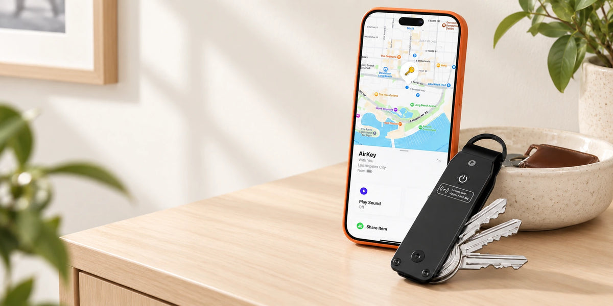 Black key organizer beside a phone showing the supplied tracking screen.