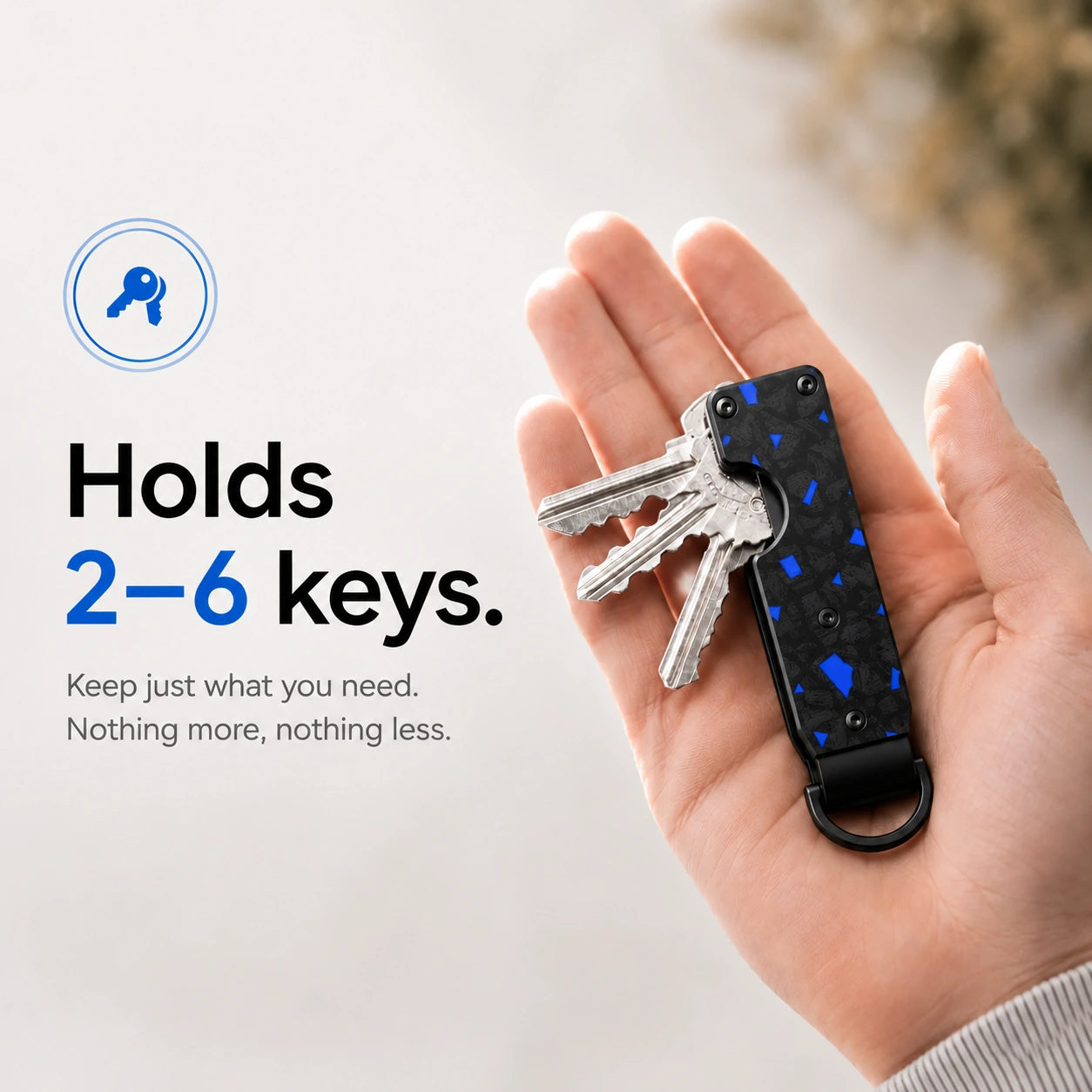 Carbon Blue compact tracking key organizer holding several keys in a palm #color_Carbon Blue